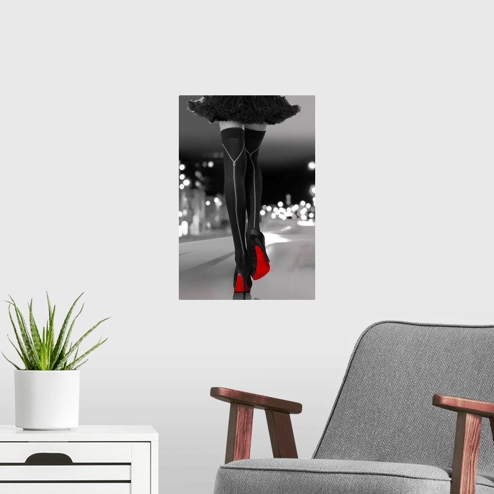 A modern room featuring Black and white photograph of a woman's long legs with black high heels and bright red soles walk...
