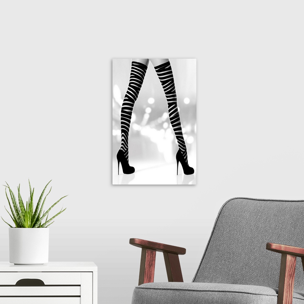 A modern room featuring Black and white photograph of a woman's long legs with black high heels and striped stalkings.