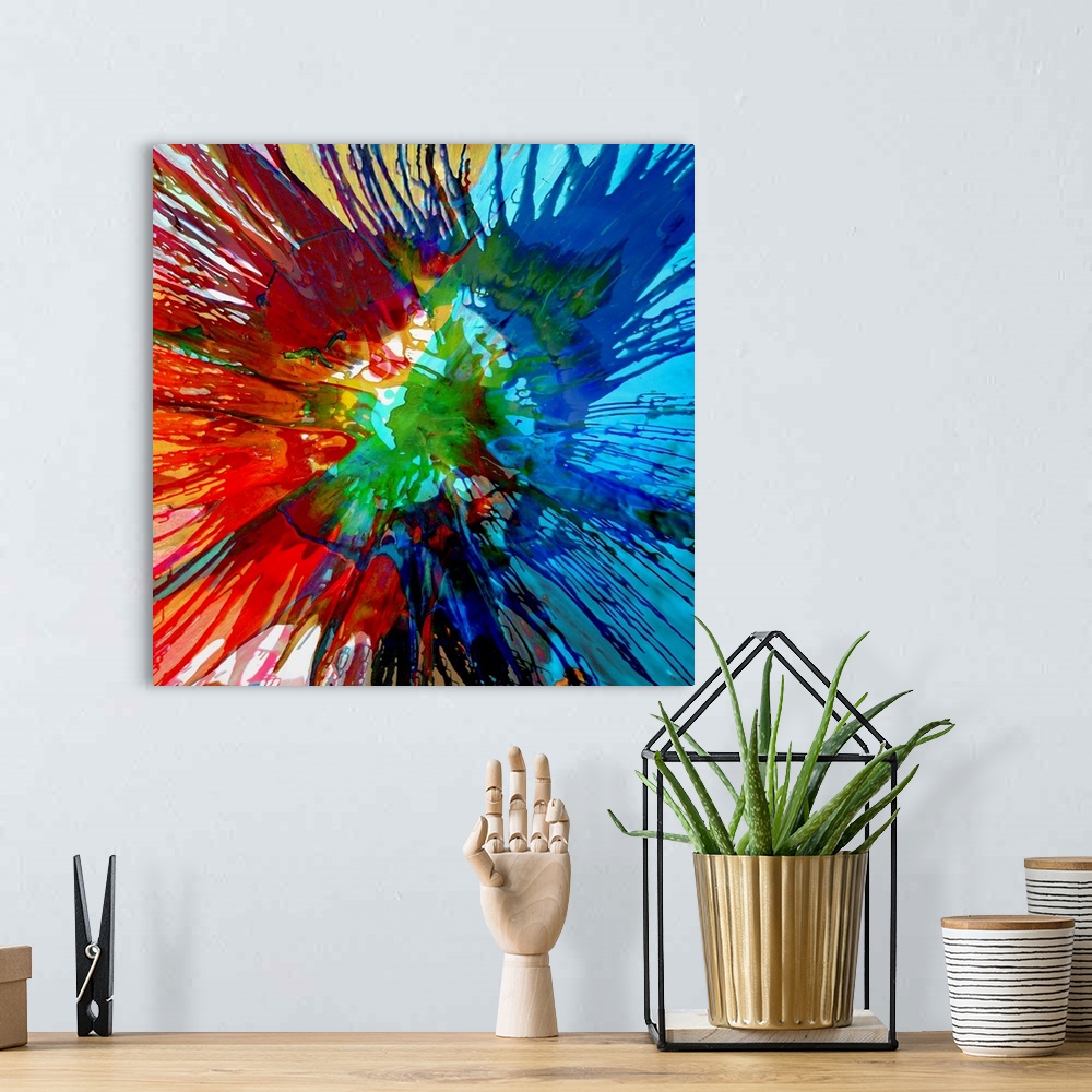 A bohemian room featuring Square abstract painting with a tie-dye effect in shades of blue, green, red, and yellow.