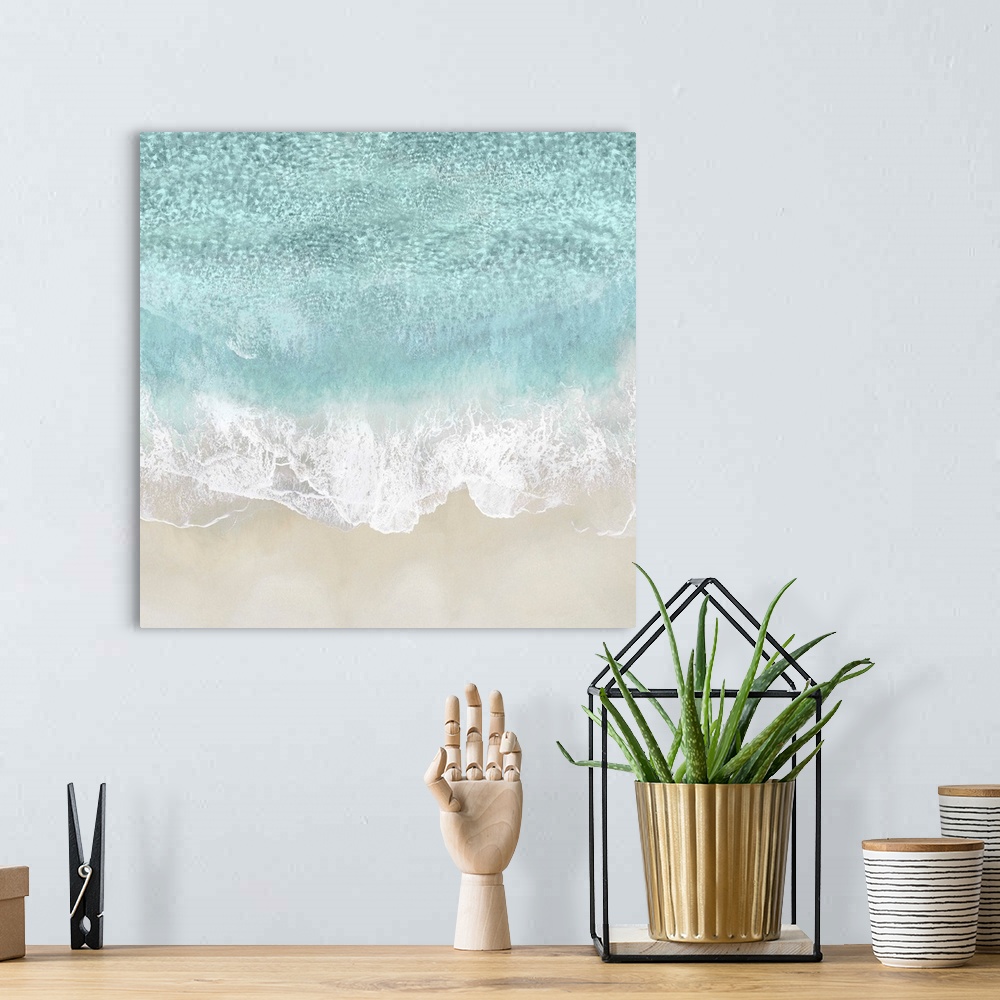 A bohemian room featuring One artwork in a series of aerial shots of a beach as light blue waves break upon the shore.