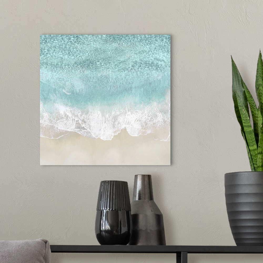 A modern room featuring One artwork in a series of aerial shots of a beach as light blue waves break upon the shore.