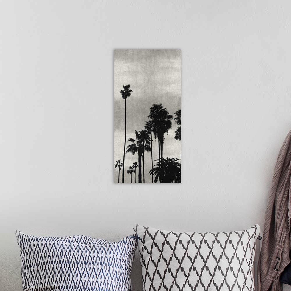 A bohemian room featuring Decorative artwork featuring a black silhouette of a palm tree over a distressed background.