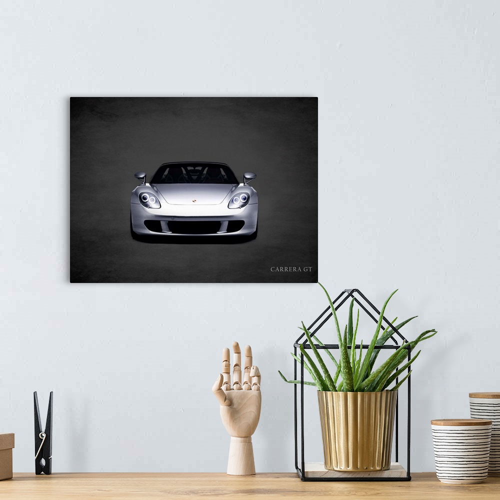 A bohemian room featuring Photograph of a silver Porsche Carrera GT printed on a black background with a dark vignette.