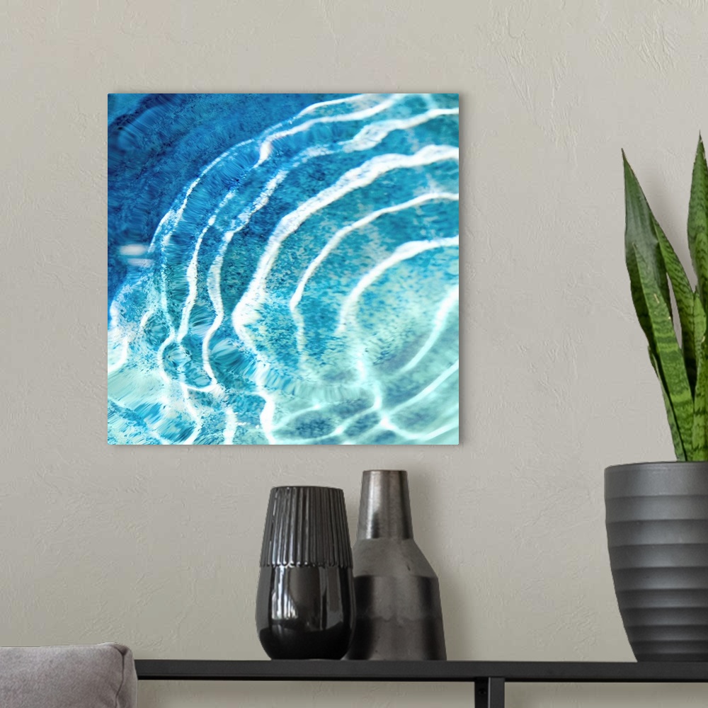 A modern room featuring Square photograph of ripples in clear blue water.