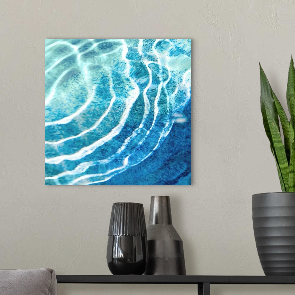 A modern room featuring Square photograph of ripples in clear blue water.