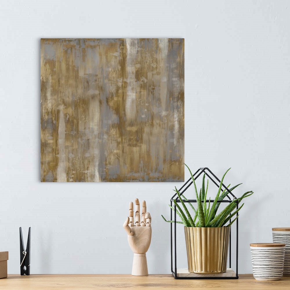 A bohemian room featuring Square abstract painting with shades of metallic gold and silver streaking down the canvas.