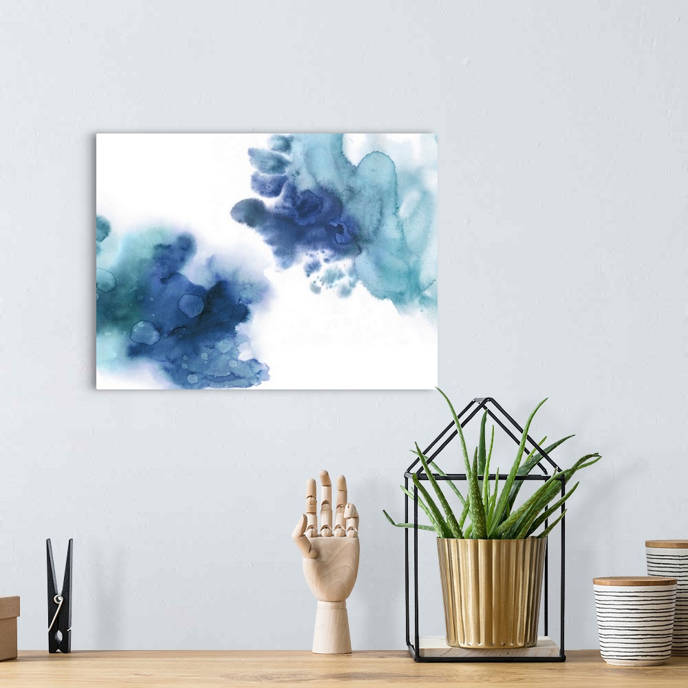 A bohemian room featuring Abstract painting with shades of blue splattered together on a white background.