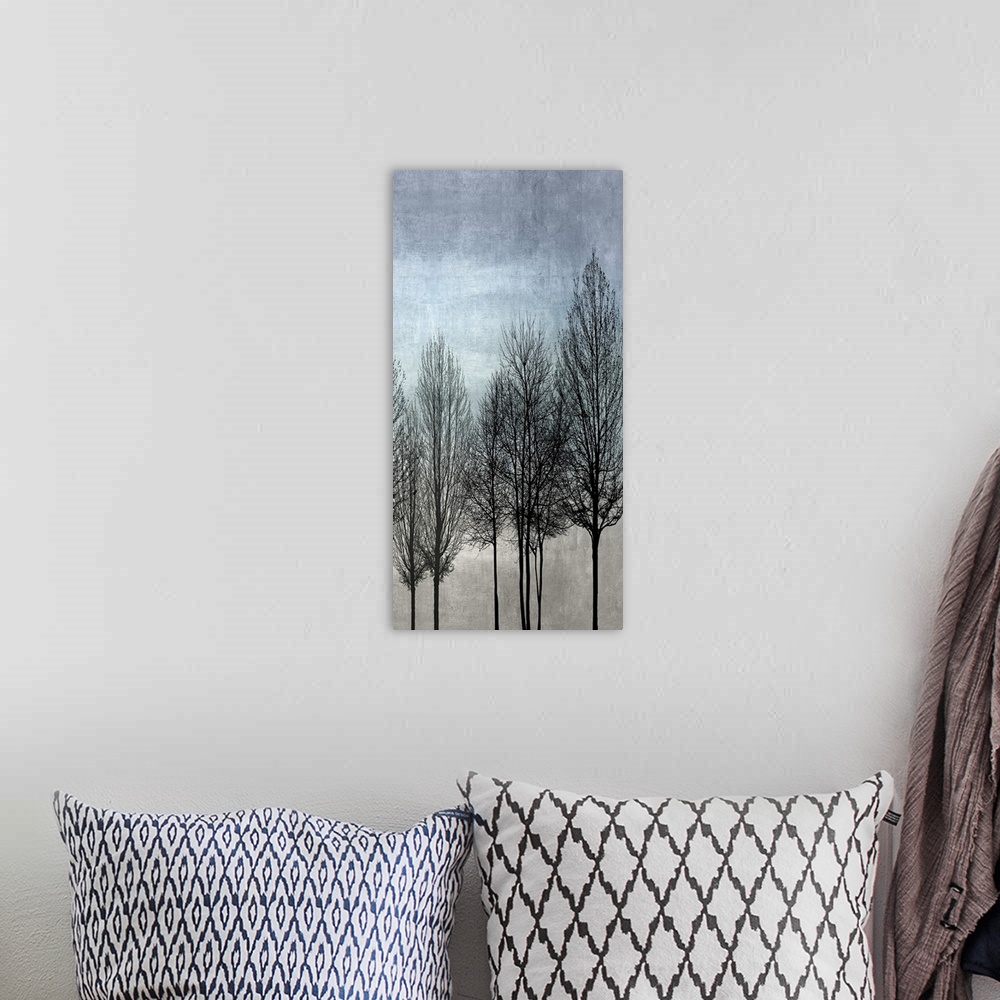 A bohemian room featuring Decorative artwork featuring a black silhouette of leafless trees over a distressed background.