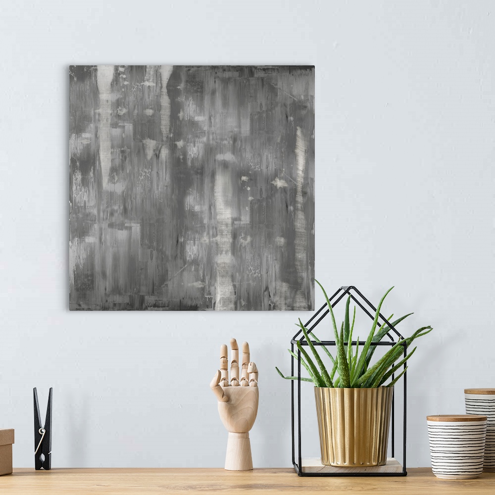 A bohemian room featuring Square abstract painting with shades of gray streaking down the canvas.