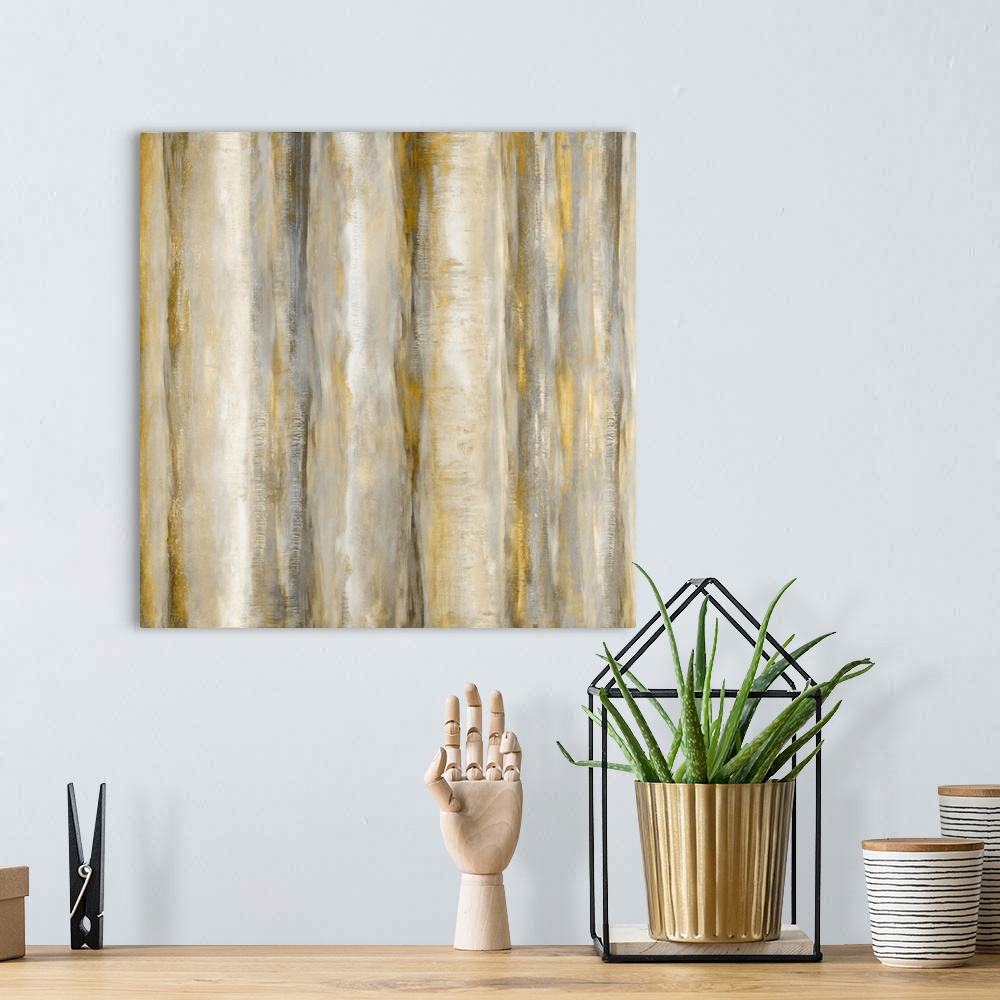 A bohemian room featuring Square abstract painting with bands of metallic gold and silver running vertically across the can...