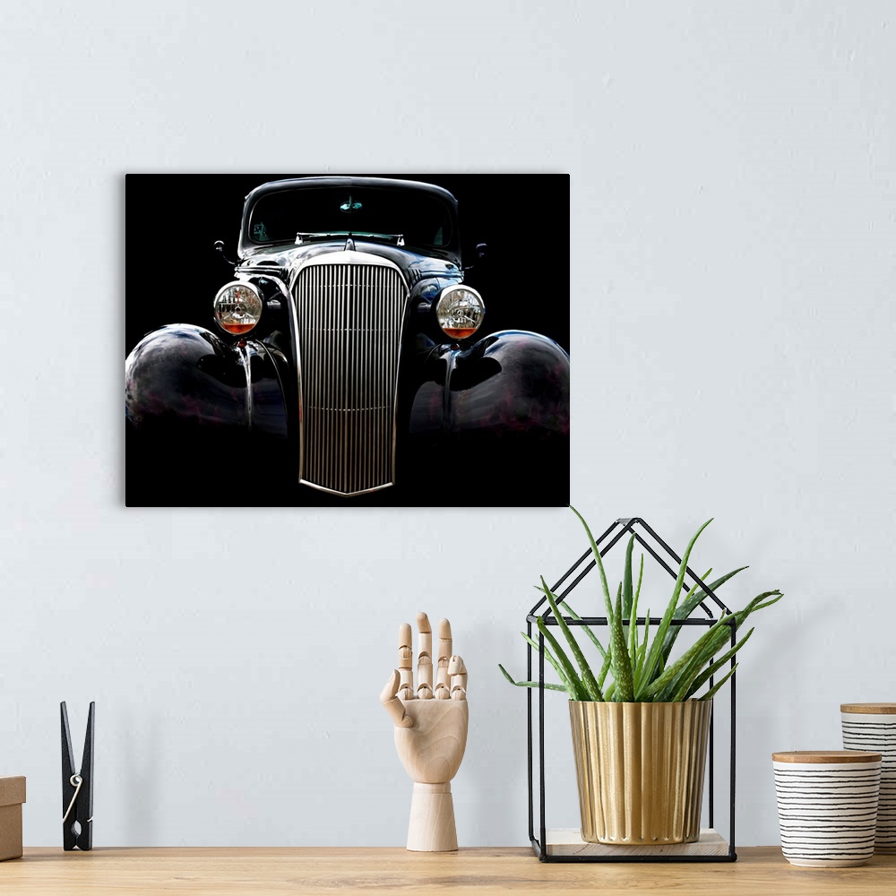 A bohemian room featuring Photograph of the front of a black vintage Chevrolet with a solid black background.