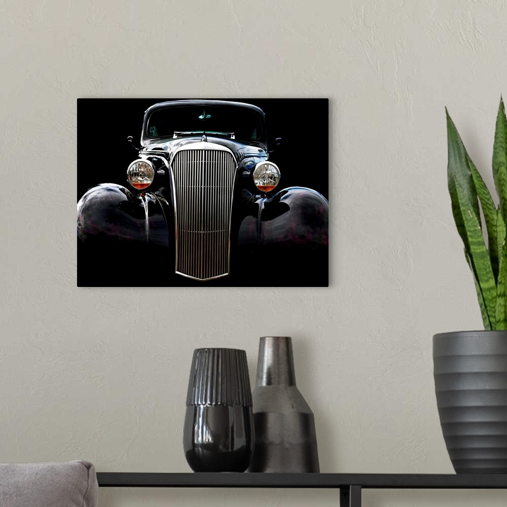 A modern room featuring Photograph of the front of a black vintage Chevrolet with a solid black background.