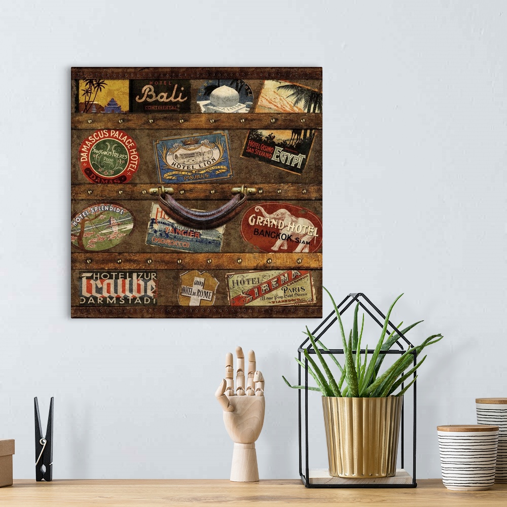 A bohemian room featuring Square decor with an image of a wooden trunk covered in travel stickers.