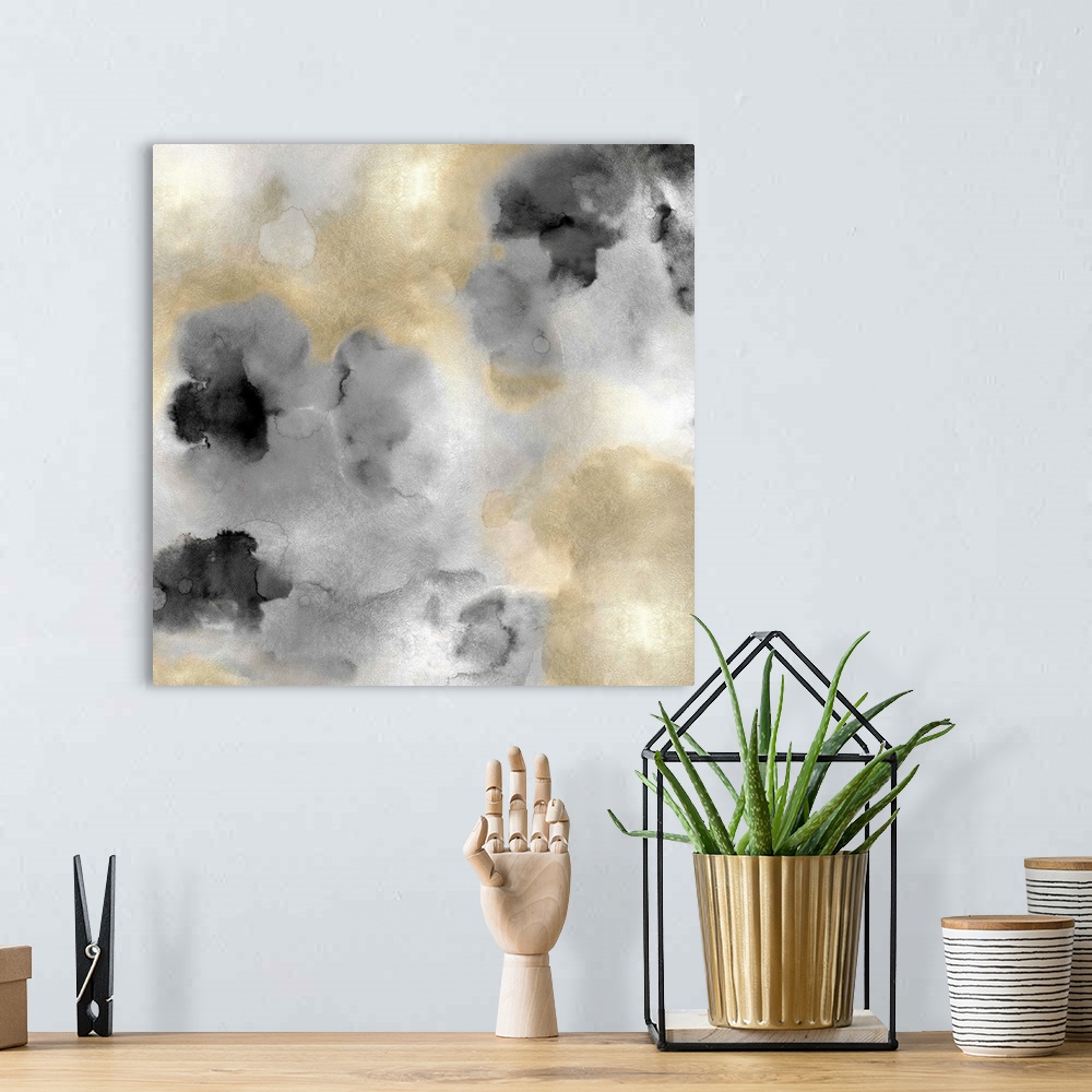 A bohemian room featuring Abstract painting with gold and black hues splattered together on a silver background.