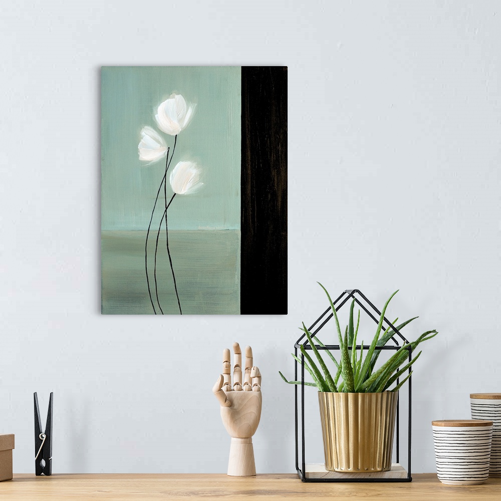 A bohemian room featuring Vertical painting of three white flowers with long stems against a teal background with a black b...