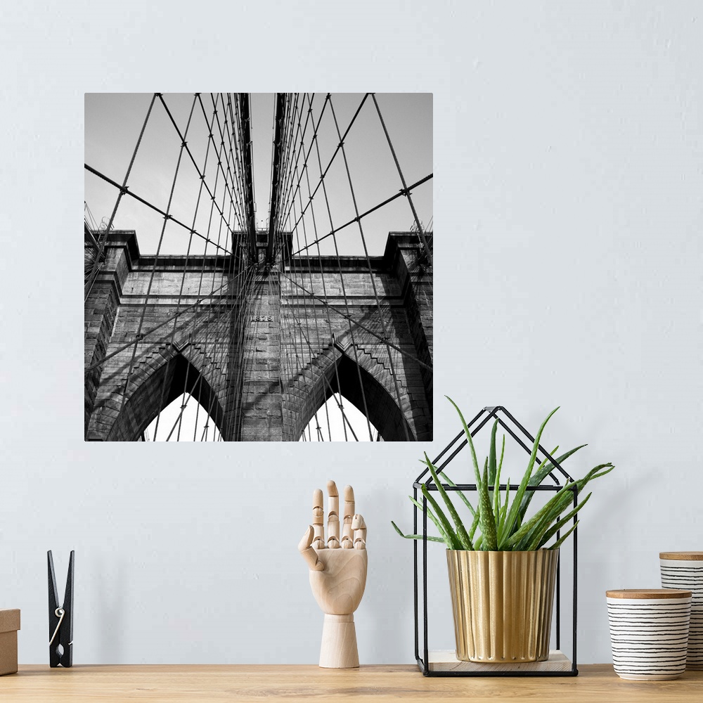 A bohemian room featuring Black and white close up of the Brooklyn Bridge.