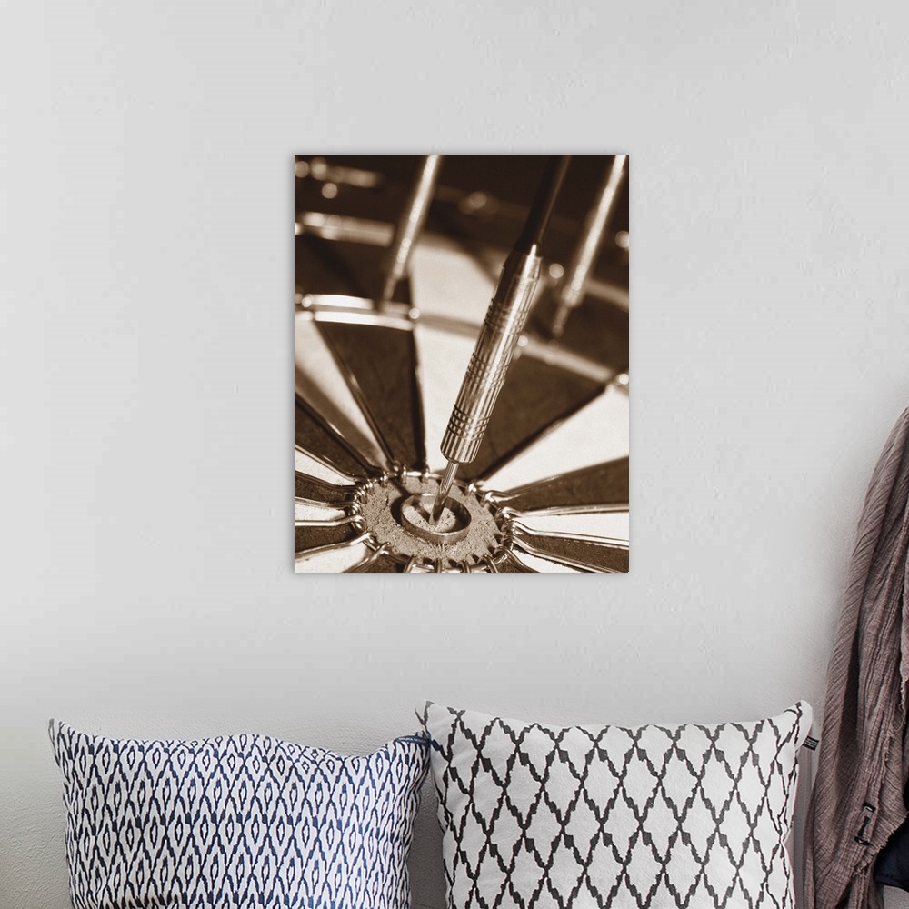 A bohemian room featuring Sepia toned photo of a dart in the center of a dart board.