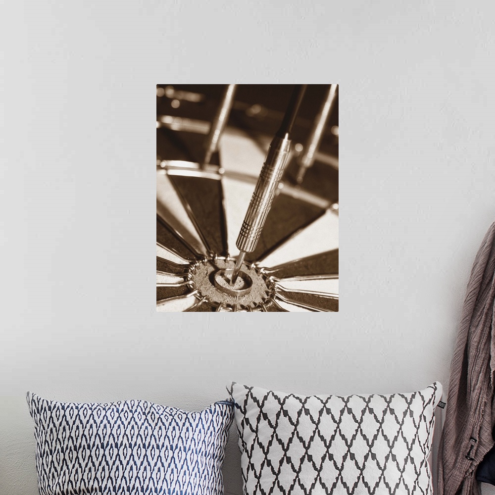 A bohemian room featuring Sepia toned photo of a dart in the center of a dart board.
