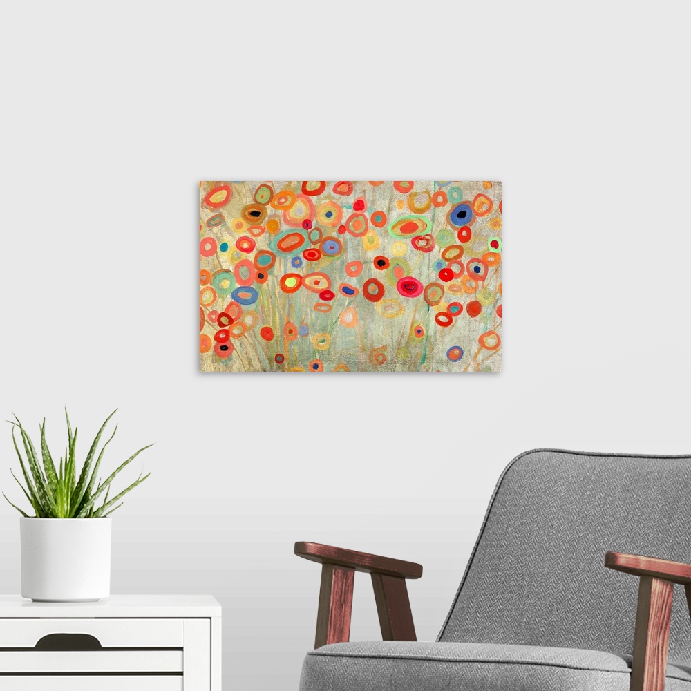A modern room featuring Horizontal painting of a group of multi-colored circles against a neutral backdrop.