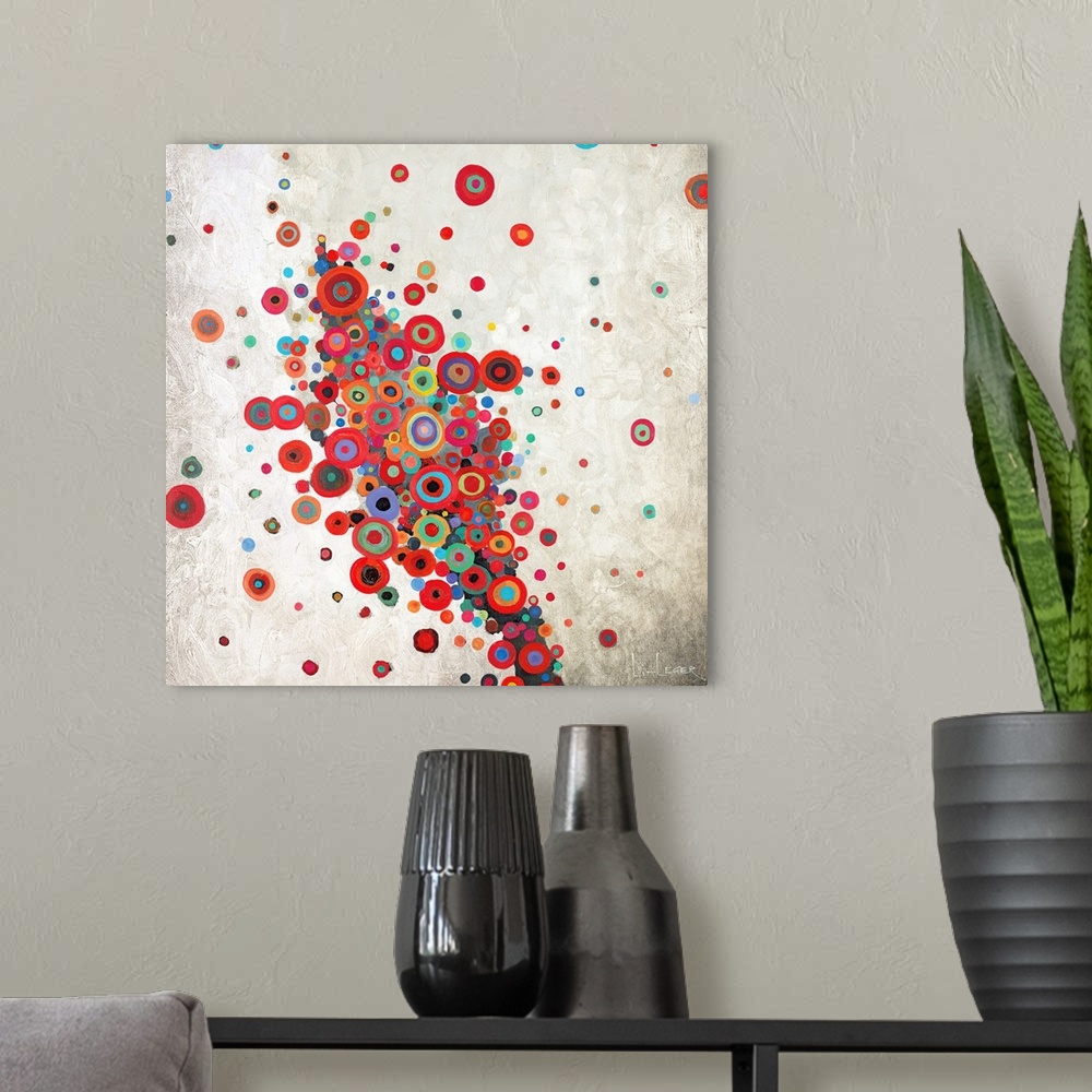 A modern room featuring Square painting of a group of multi-colored circles against a neutral backdrop.