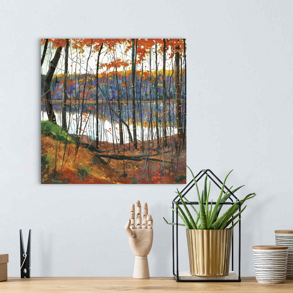 A bohemian room featuring A colorful fall scene of a forest surrounding a lake with the trees reflecting in the water.