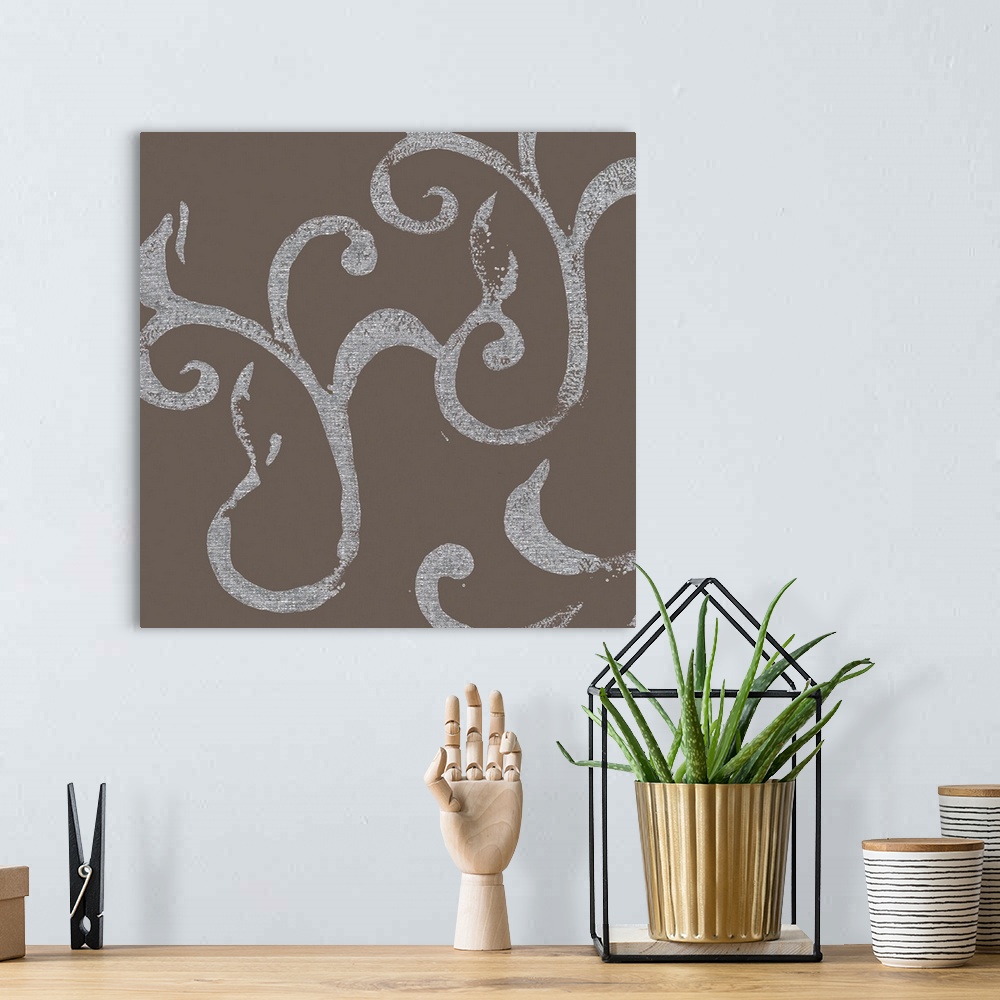 A bohemian room featuring A square abstract of flourish swirls in silver against of gray backdrop.