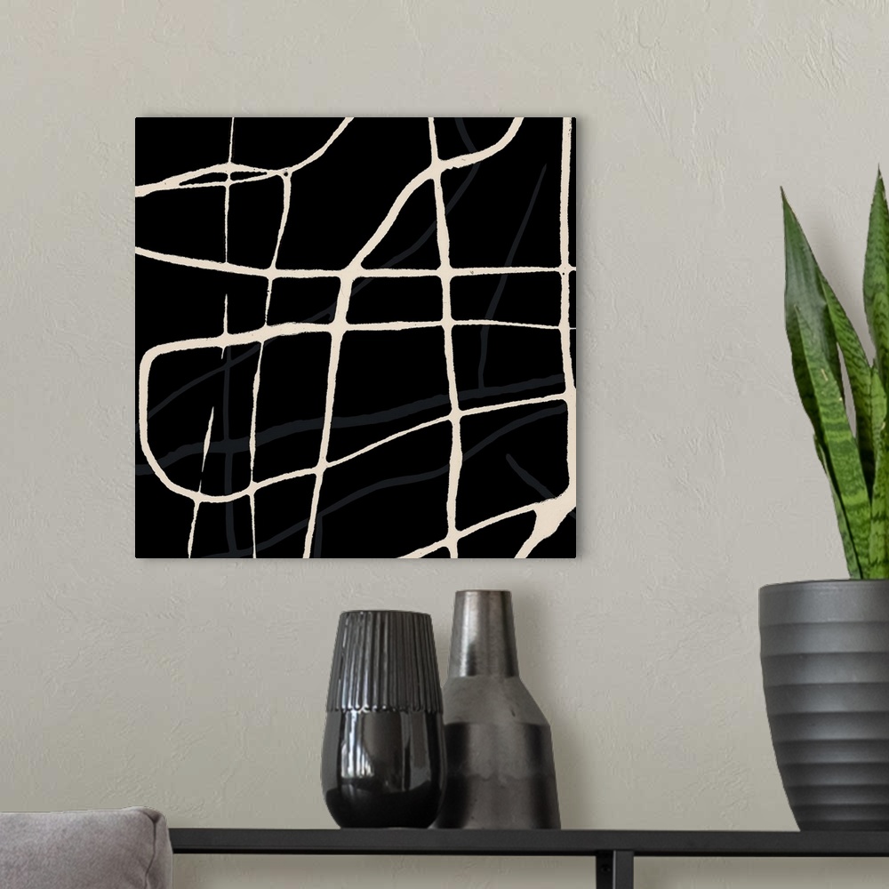 A modern room featuring A square abstract of beige drips of paint overlaying in varies directions with a black backdrop.