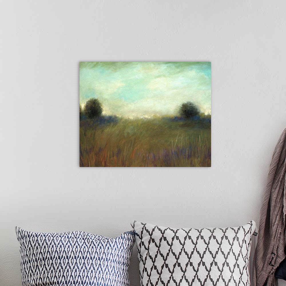 A bohemian room featuring A muted contemporary painting of tall grass in a field with a line of trees in the background.