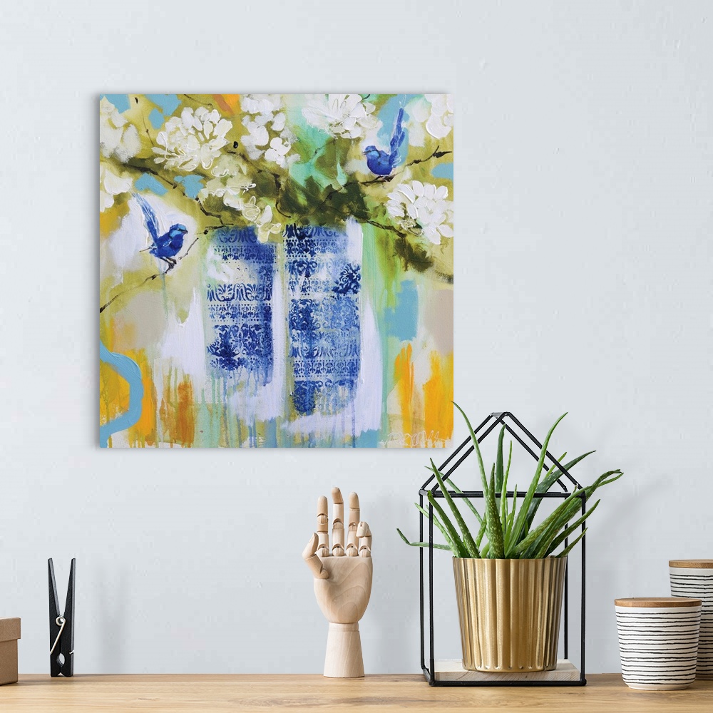 A bohemian room featuring Square painting of two vases, with a blue floral design, full of white flowers and two blue birds...