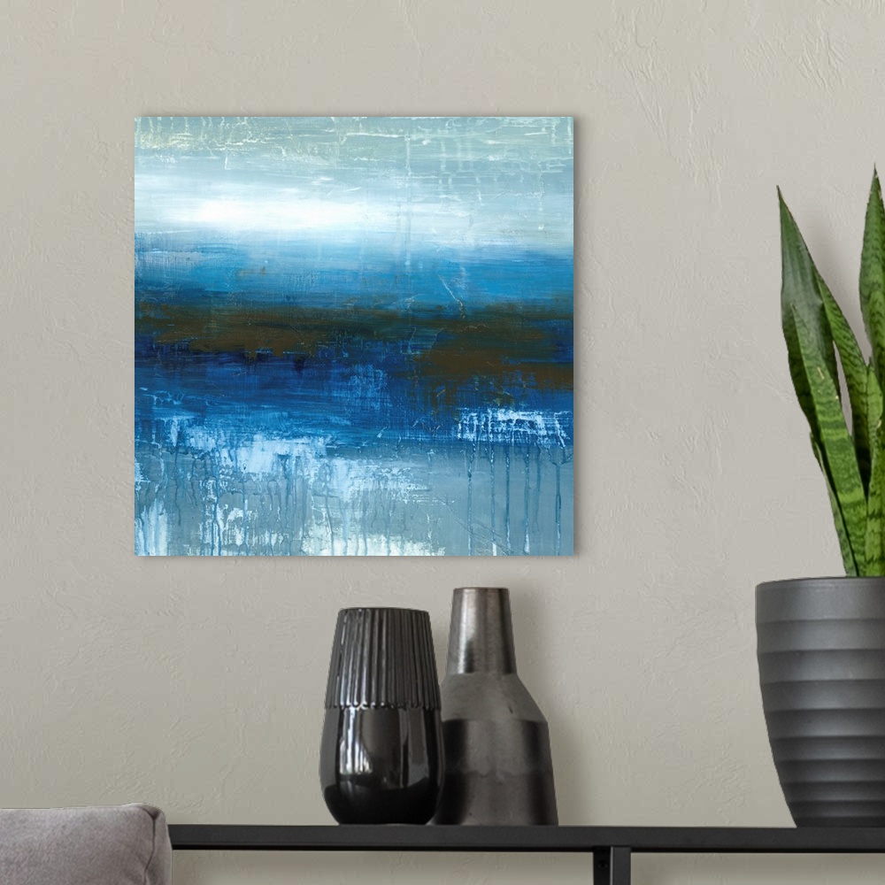 A modern room featuring Square abstract painting in textured colors of blue, white and gray.