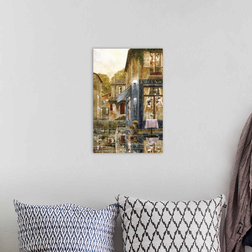 A bohemian room featuring Vertical artwork of a evening street scene in Europe of a single table outside of a restaurant wi...