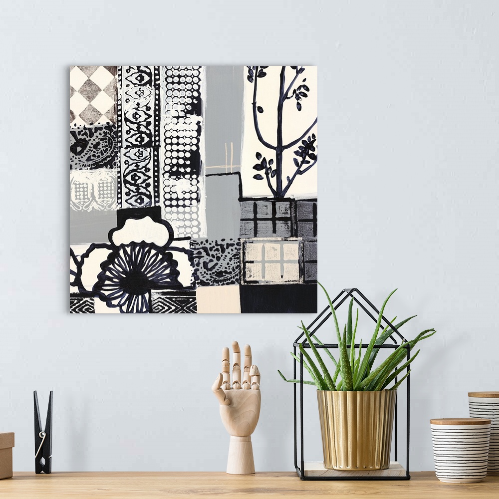 A bohemian room featuring Black and white painting of squared shapes of varies patterns and a large flower on the left.