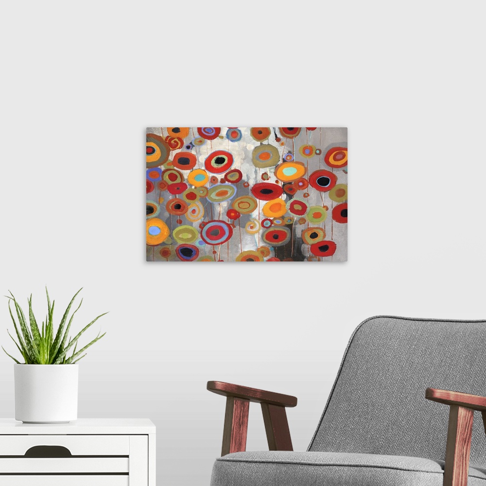 A modern room featuring A horizontal abstract of bright multi-colored flowers on a neutral backdrop.