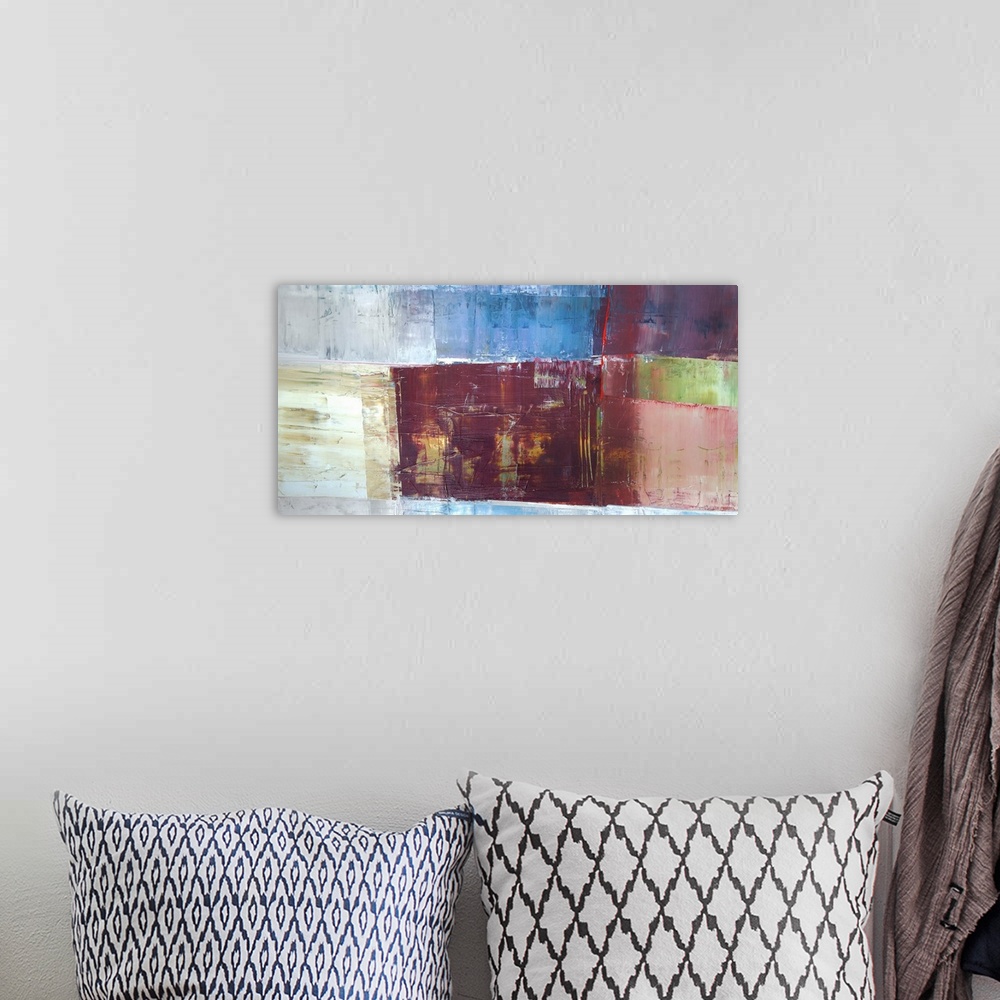 A bohemian room featuring A horizontal abstract painting in textured colors of brown, blue and red in box shapes.