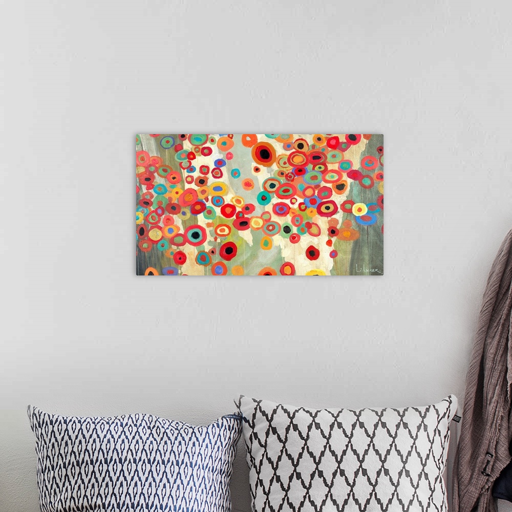 A bohemian room featuring Horizontal painting of a group of multi-colored circles against a neutral backdrop.