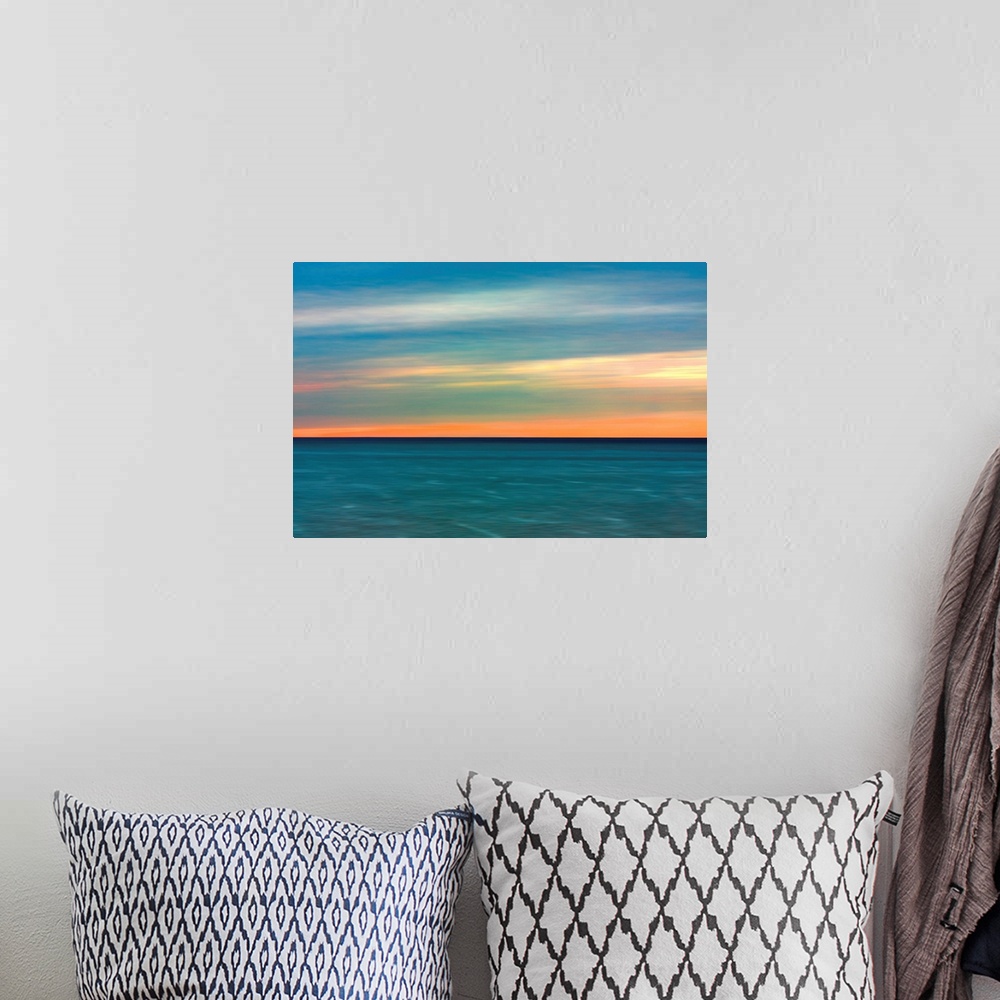 A bohemian room featuring Horizontal image of a color sunset over calm ocean waters.