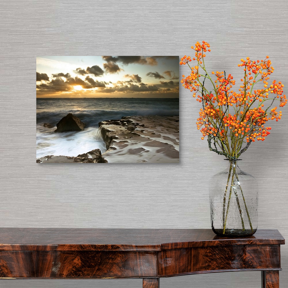 A traditional room featuring Image of a rocky coastline during a cloudy sunset.