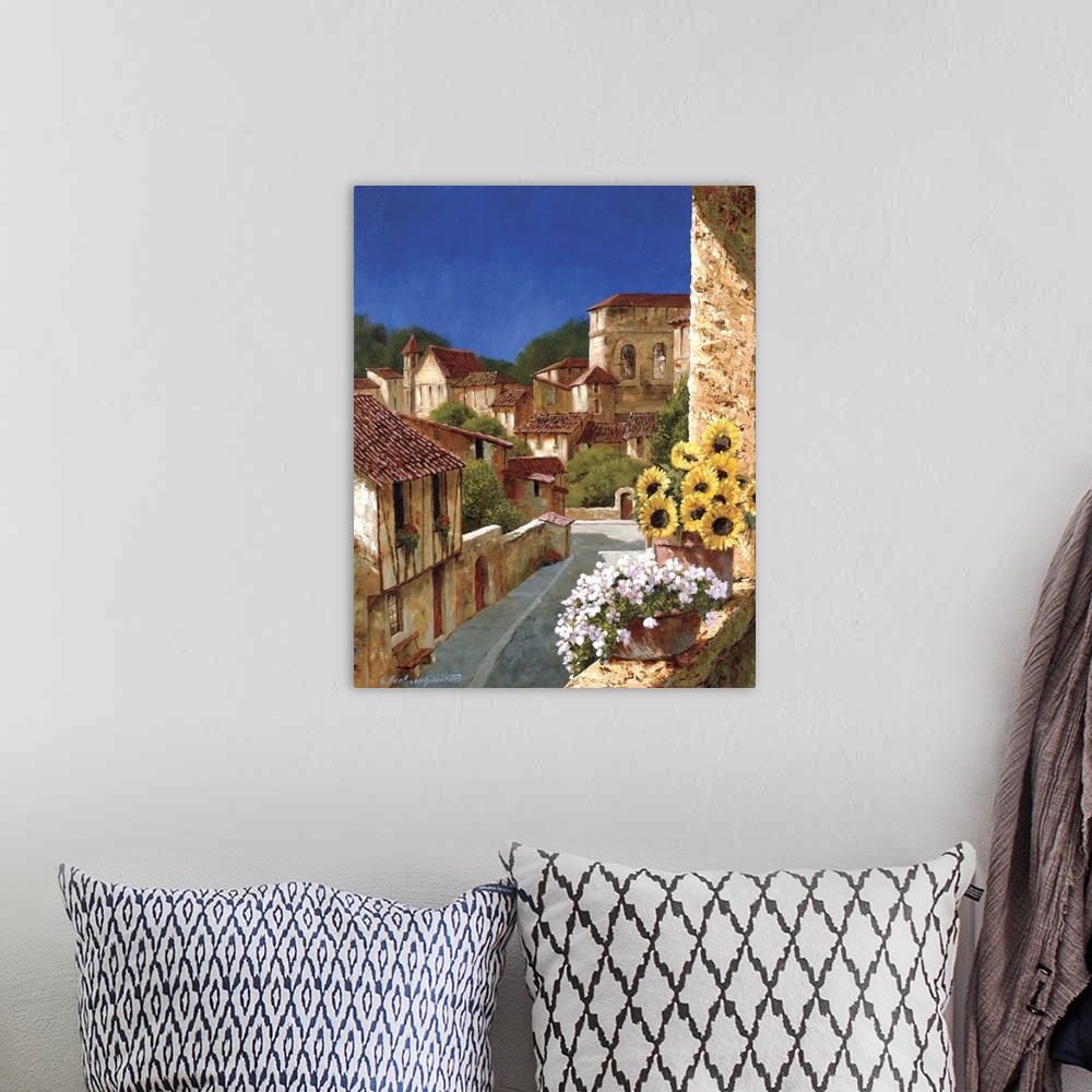 A bohemian room featuring A vertical complementary painting of buildings of stone and terracotta in a village in Europe.