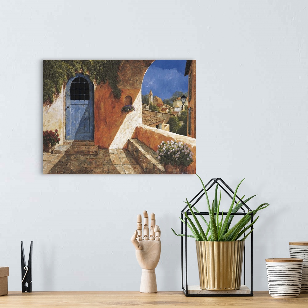A bohemian room featuring Contemporary artwork of a blue door near an archway in a European village.