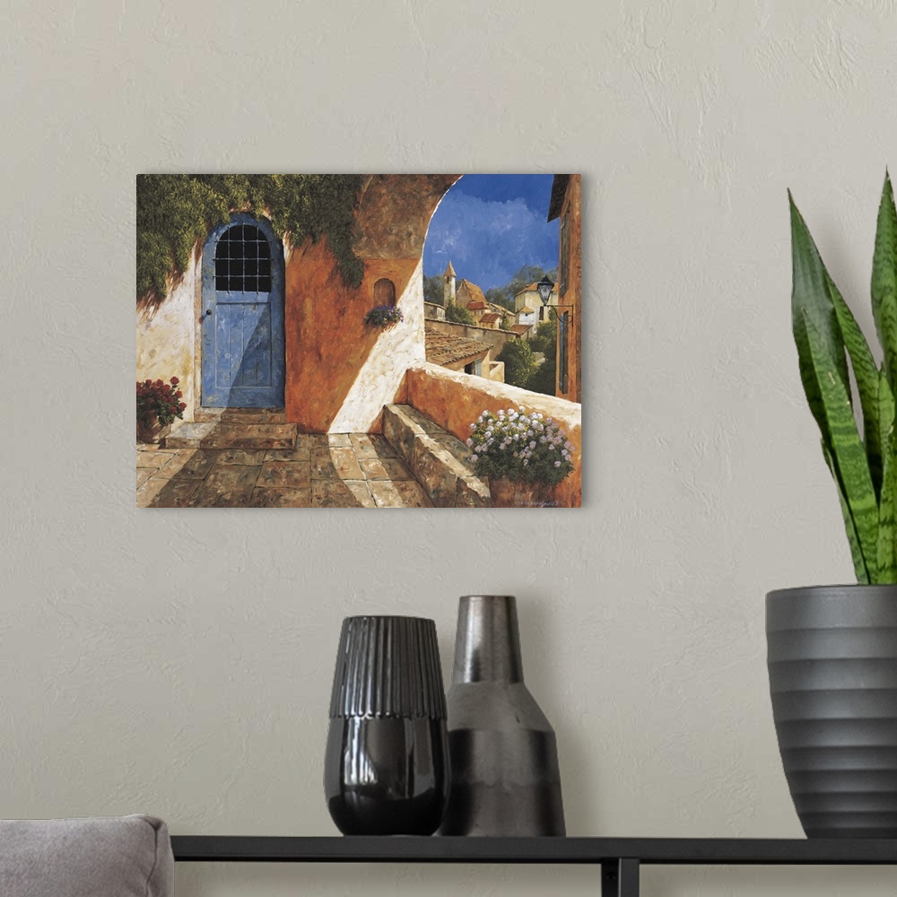 A modern room featuring Contemporary artwork of a blue door near an archway in a European village.