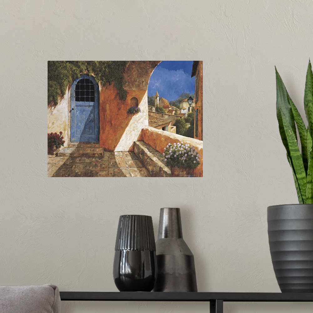 A modern room featuring Contemporary artwork of a blue door near an archway in a European village.