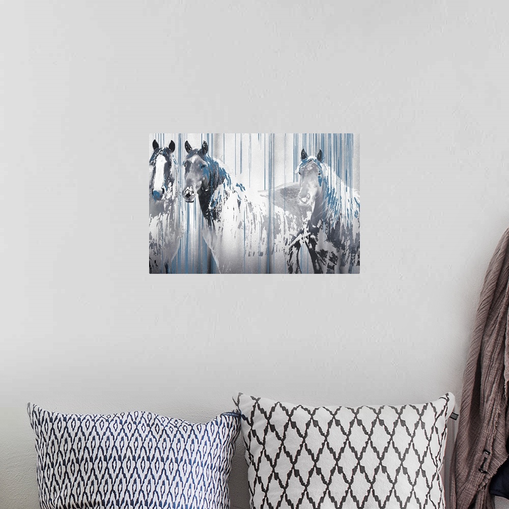 A bohemian room featuring A composite image of three horses in tones of gray with drips of blue paint overlapping the image.