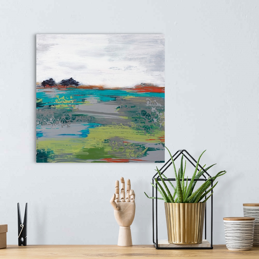 A bohemian room featuring A modern abstract landscape of a field with a few trees and a grey sky.