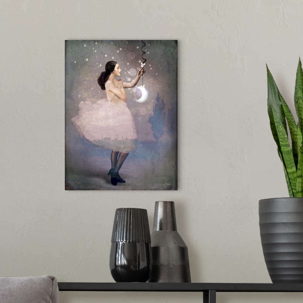 A modern room featuring A lady in pink is holding a crescent moon hanging from a ribbon.