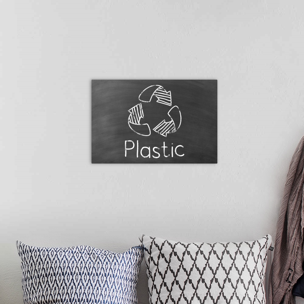 A bohemian room featuring Recycling symbol with "Plastic" written underneath in white on a black chalkboard background.