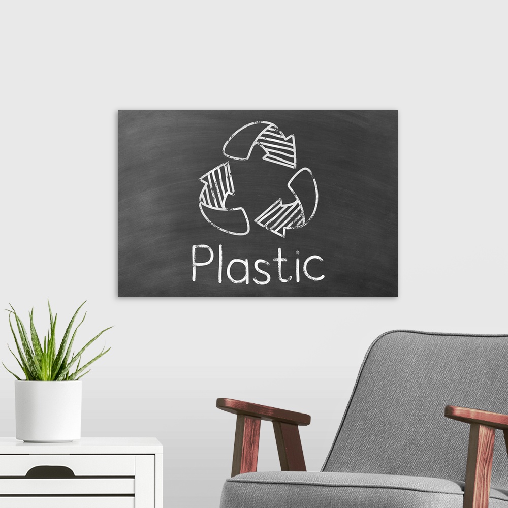 A modern room featuring Recycling symbol with "Plastic" written underneath in white on a black chalkboard background.