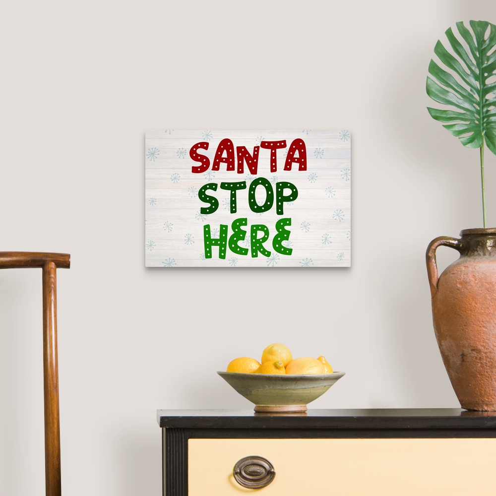 A traditional room featuring Graphic holiday art with large decorative text on a horizontally striped background with light sn...