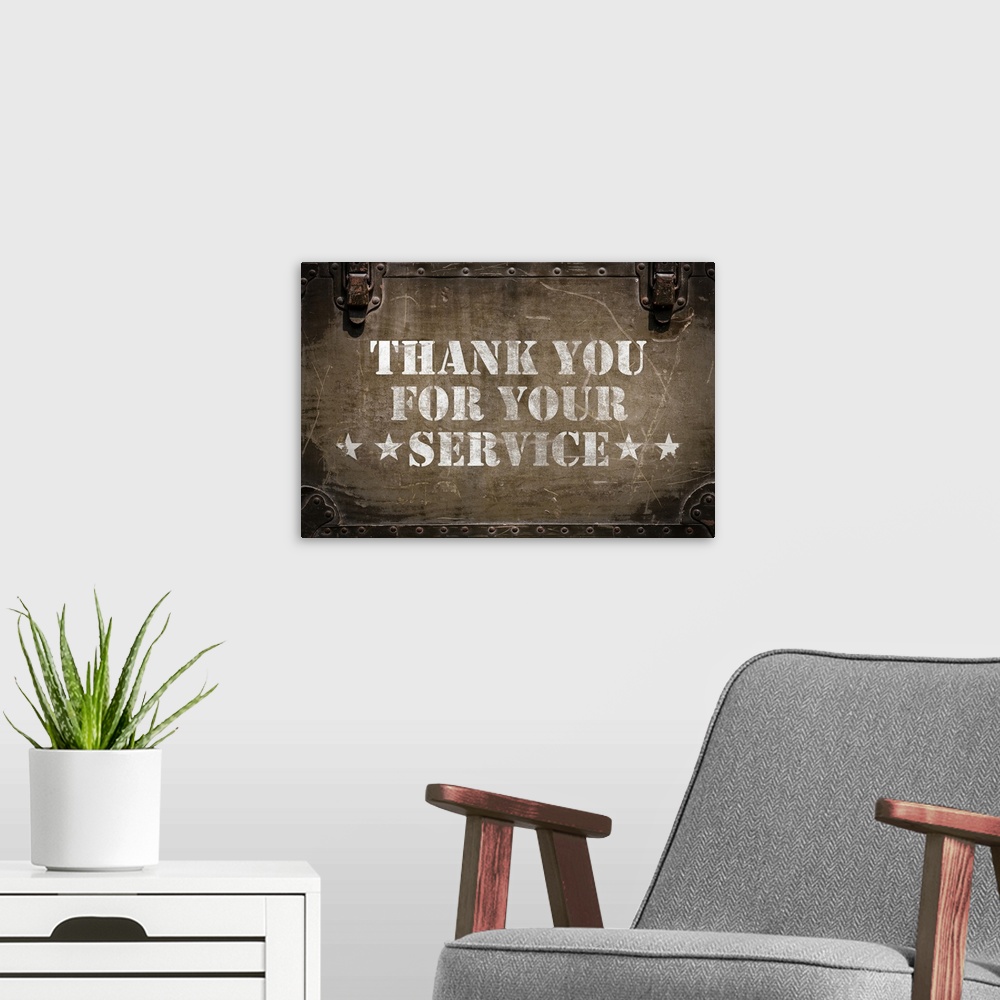 A modern room featuring "Thank You For Your Service" stenciled in white on a worn trunk.