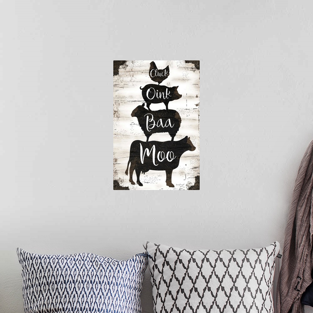 A bohemian room featuring Graphic art of silhouettes of a cow, sheep, pig and chicken, stacked upon one another, with scrip...