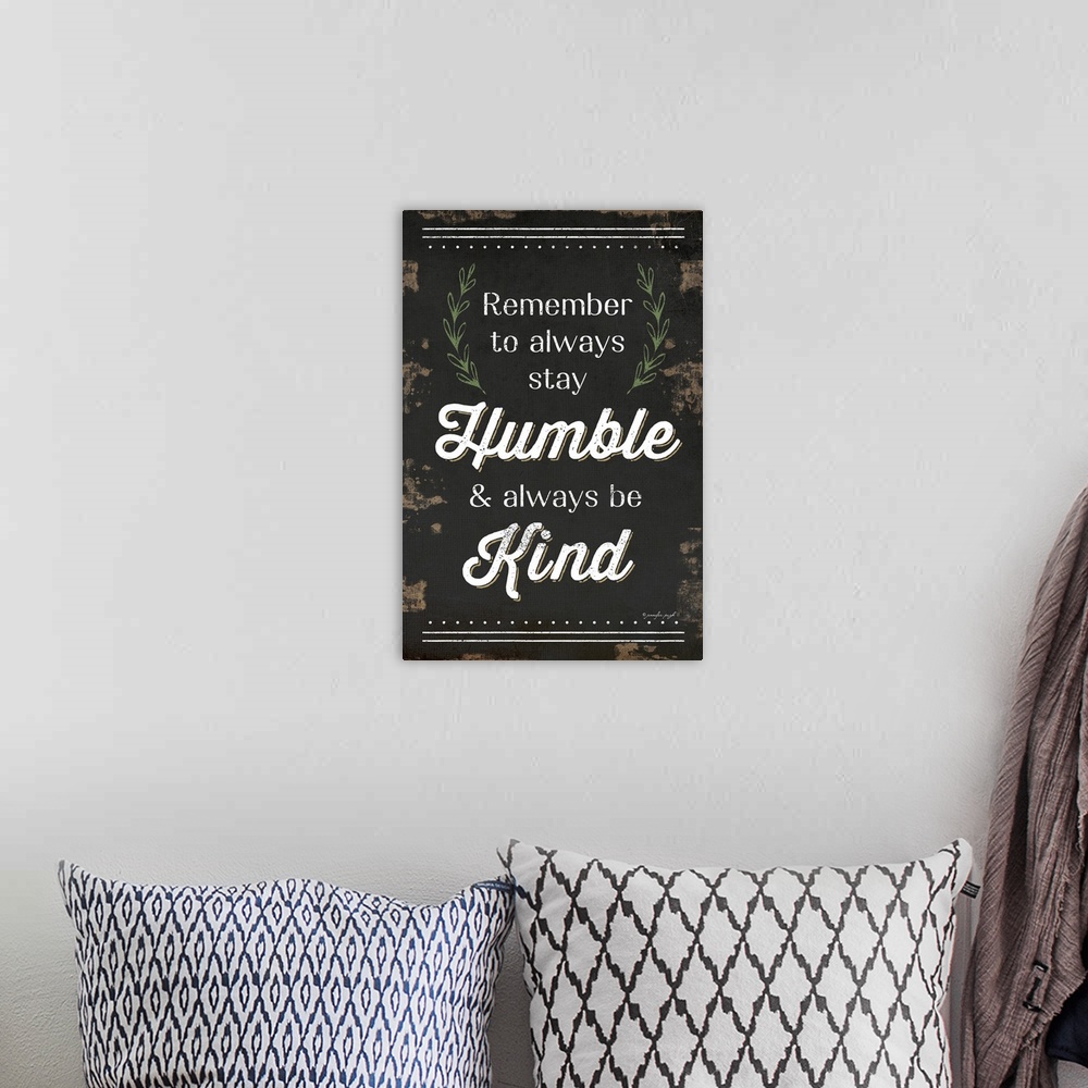 A bohemian room featuring "Remember to always stay Humble and always be Kind" on a weathered dark background.